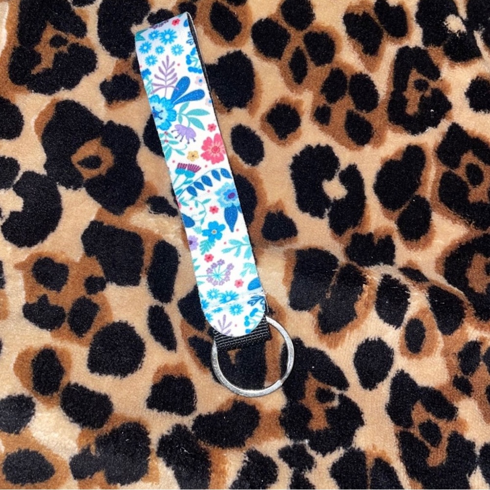 This a a keychain with a white base and colorful flowers.